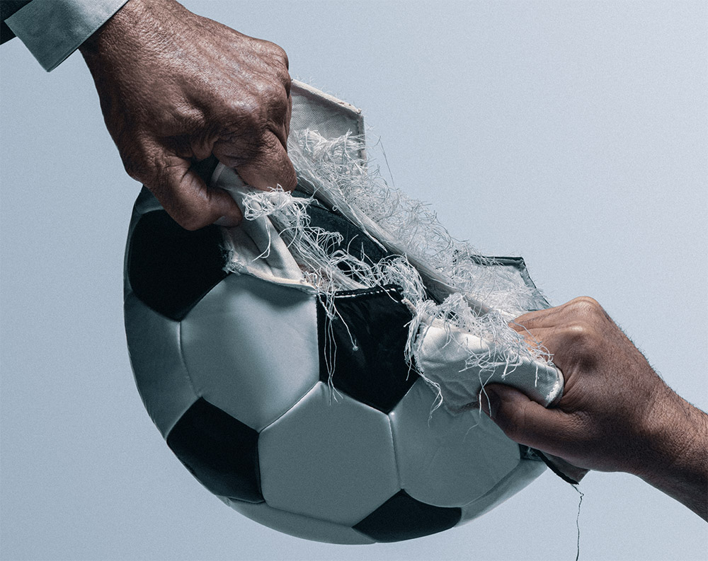 Two hands ripping apart a football