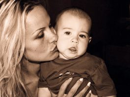 woman kissing hold a baby and kissing his cheek.