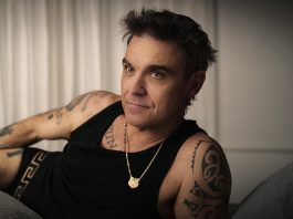 Robbie Williams lying on a bed